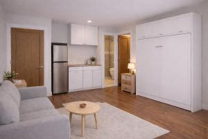 a living room with a couch and a kitchen at Bolishka Whispers, Spacious Bright Studio accom in Galway