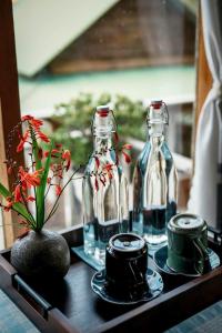a table with two glass bottles and a vase with flowers at Nhà Để Chill Homestay in Da Lat