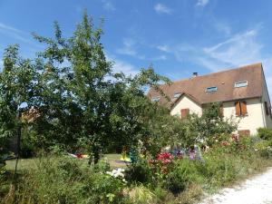 a house with a tree and flowers in the yard at L'auberge d'authie in Authie