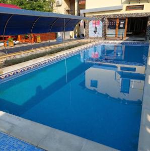 a swimming pool with blue water in a building at Motel Biamin in Tăşnad +24 photos