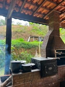 an outdoor grill with two pots and pans on it at Chácara Desejo do Coração 1 in Juquitiba
