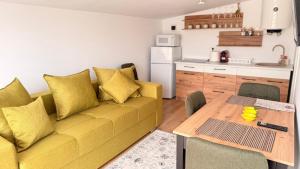 a living room with a yellow couch and a table at Vraja din deal in Domneşti