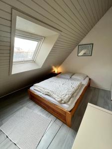 a bedroom with a bed in a attic with a window at T1 bis 200m du port in La Trinité-sur-Mer