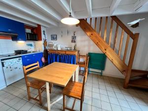 a kitchen with a table and chairs and a staircase at T1 bis 200m du port in La Trinité-sur-Mer