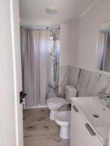 a white bathroom with a toilet and a sink at Casa Joe in Corbu +22 photos