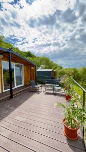a deck with a bench and some plants on it at Vraja din deal in Domneşti