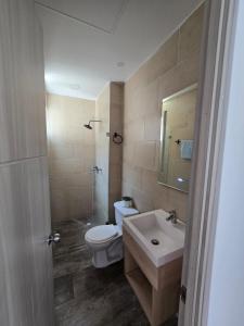 a bathroom with a white toilet and a sink at Apartamento cómodo completo y familiar in Ibagué +3 photos