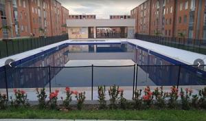 a large swimming pool in a building with buildings at Apartamento cómodo completo y familiar in Ibagué