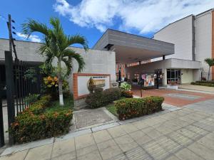 a building with a palm tree in front of it at Apartamento cómodo completo y familiar in Ibagué