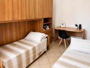 a bedroom with two beds and a desk and a table at Casa Iris in Montepulciano