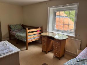 a bedroom with a desk and a bed and a window at Saint Quintin Hotel in Harpham