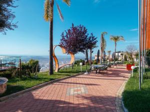 a brick walkway with a park with a playground at Festim Villa Hotel in Kaninë