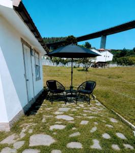 a patio with two chairs and an umbrella at La Casona de Carcedo 3 in OVD