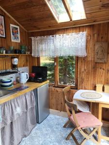 a kitchen with a counter and a table and a window at Retro domki nad Wkrą in Kosewko