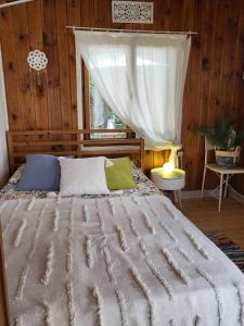 a bedroom with a large bed with a window at Retro domki nad Wkrą in Kosewko