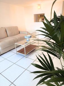 a living room with a couch and a table and a plant at The Six Ortigia Residences in Syracuse