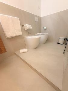 a bathroom with two sinks and a toilet in it at The Six Ortigia Residences in Syracuse