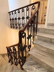 a stairway with a black rail and a stair case at The Six Ortigia Residences in Syracuse