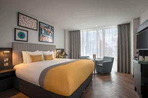 a hotel room with a large bed and a desk at Maldron Hotel Croke Park in Dublin