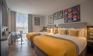 a hotel room with two beds and a table at Maldron Hotel Croke Park in Dublin