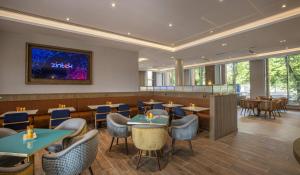 a restaurant with tables and chairs and a bar at Maldron Hotel Croke Park in Dublin +19 photos