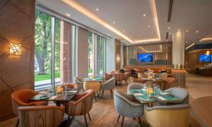 a restaurant with tables and chairs and a large window at Maldron Hotel Croke Park in Dublin