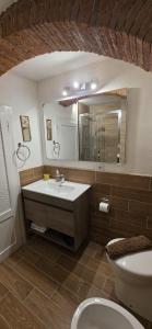 ein Badezimmer mit Waschbecken, Toilette und Spiegel in der Unterkunft La Volta Garibaldi in Barga