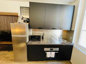 a kitchen with a refrigerator and a sink at Le Charmant Bailla Science-Po in Reims