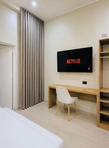 a hotel room with a desk and a television on the wall at Kigelia Hotel in Tumbes