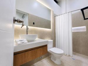 a bathroom with a sink and a toilet at Kigelia Hotel in Tumbes