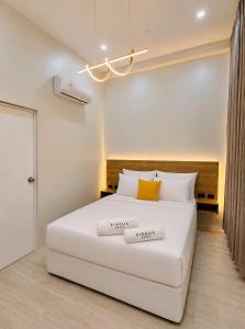 a bedroom with a large white bed with two towels on it at Kigelia Hotel in Tumbes
