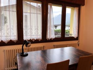 a table with a lamp in a room with windows at Sunflower Apartment in Dogna