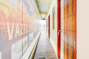 a hallway with a red door and posters on the walls at Super HOTEL O UTSAV STAY in Jālahalli