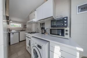 a kitchen with a washer and dryer at Classic Breeze - vista mare - terrazza - WiFi in Varazze