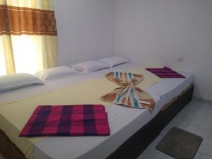 a bed with two towels on top of it at Sadew Villa in Anuradhapura