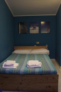 ペスカーラにあるBed & Breakfast Flaianoの青いベッドルーム(タオル付きのベッド付)