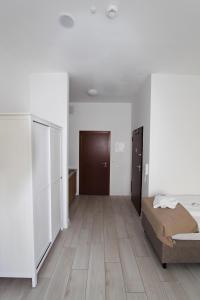 a bedroom with a bed and a wooden floor at Trzy Wyspy Apartments - Aquamarina in Świnoujście