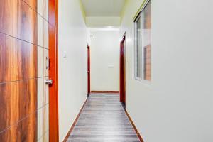 a hallway with two doors and a wooden floor at Super HOTEL O UTSAV STAY in Jālahalli