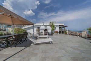 a patio with chairs and tables and an umbrella at Classic Breeze - vista mare - terrazza - WiFi in Varazze