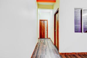 a hallway with wooden floors and doors at Super HOTEL O UTSAV STAY in Jālahalli