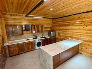 a kitchen with wooden walls and a counter top at اكواخ لاكجري ابها in Abha