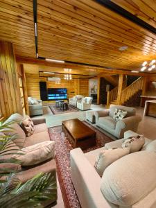 a large living room with couches and a tv at اكواخ لاكجري ابها in Abha