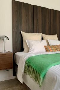 a bedroom with a bed with a green blanket on it at PATERSHOF vakantieverblijf in Diest