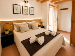 a bedroom with a large bed with bows on it at El Cajigar Ordesa Aínsa in Laspuña