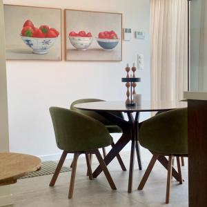 a dining room with a table and two green chairs at PATERSHOF vakantieverblijf in Diest