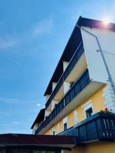 a yellow and black building with a balcony at Ferienpension Garni in Sankt Kanzian
