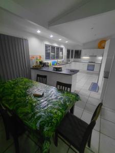 a kitchen with a table with a green blanket on it at Muaicolo House in Suva