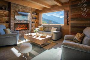 a living room with a couch and a fireplace at Chalet Serbijanka Alpine Retreat with Hammam Sauna and Jacuzzi for 14 Gueststs in Manigod