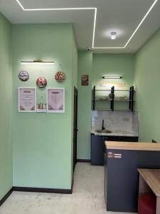 a kitchen with green walls and a counter with a sink at Eco Otel in Quba