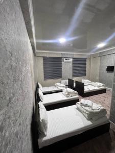 a room with four beds and a wall at Sohil Hotel in Stantsiya Kyzyl-Tukumachi